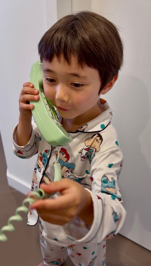 Boy talking on a green phone